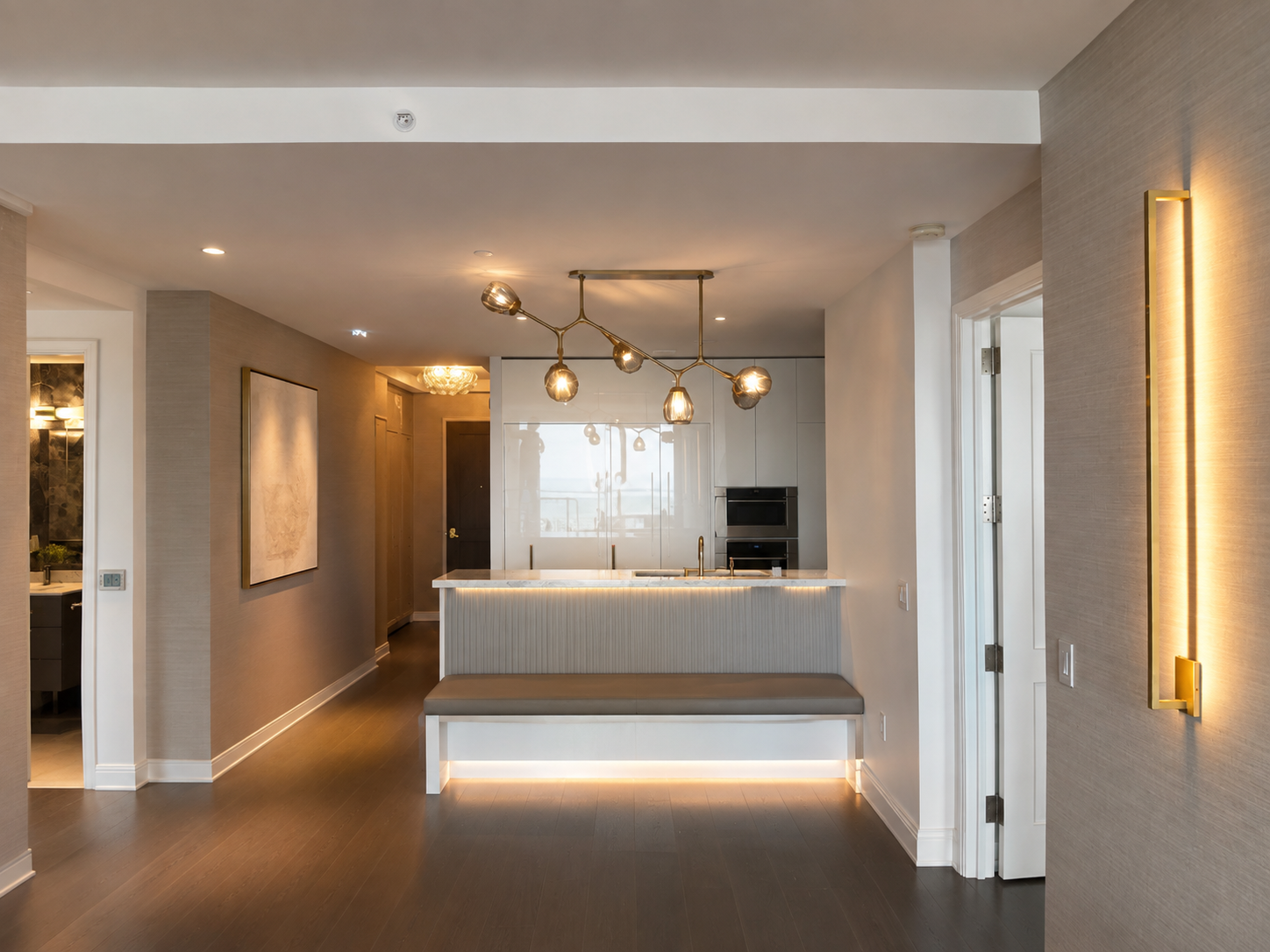 Sculptural branching chandelier with smoked glass globes and brass wall sconce in luxury Downtown Boston residence by Luster and Volt
