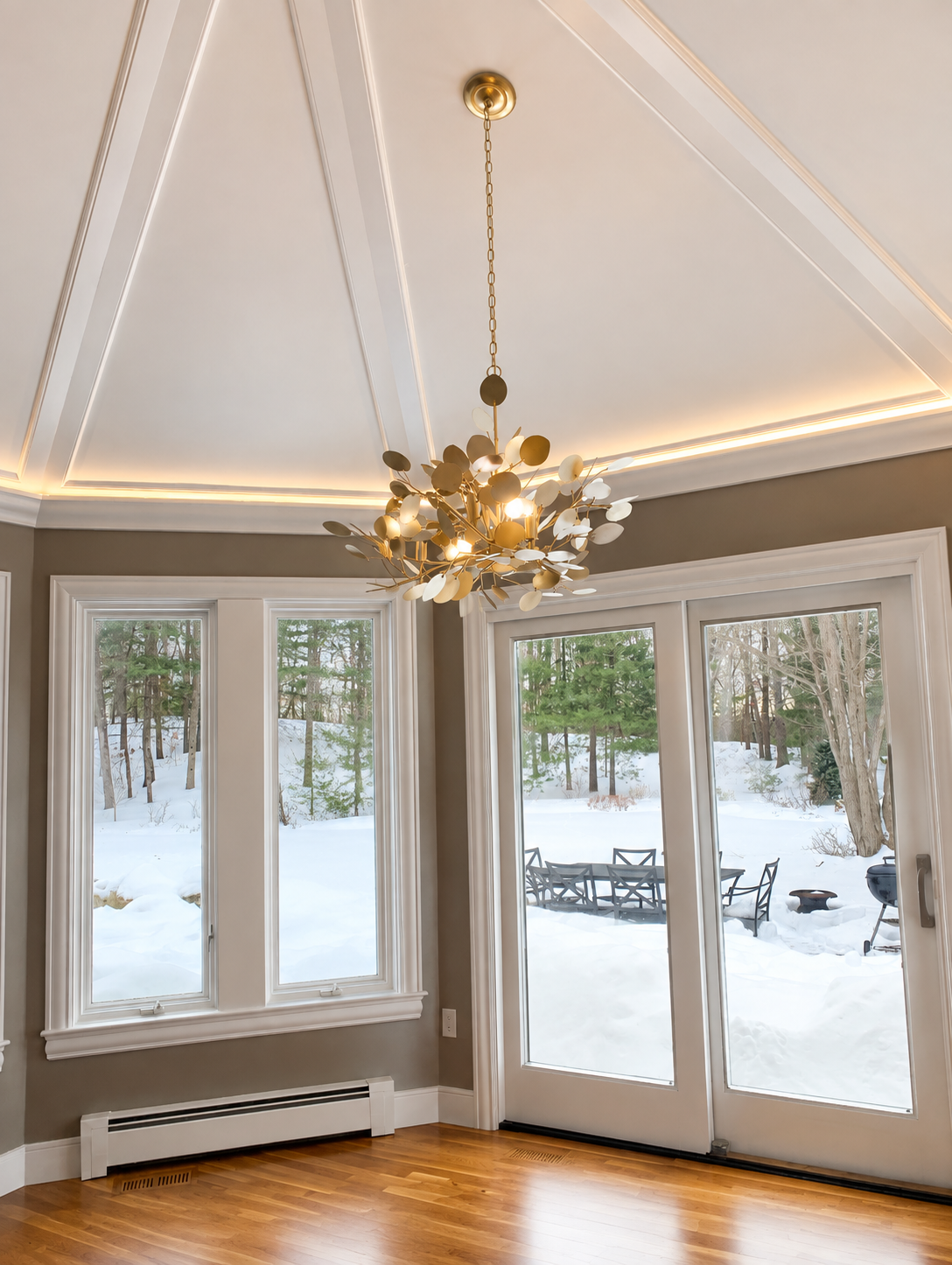 Currey and Company sculptural brass disc chandelier installed under coffered pyramid ceiling in Dover MA residence by Luster and Volt