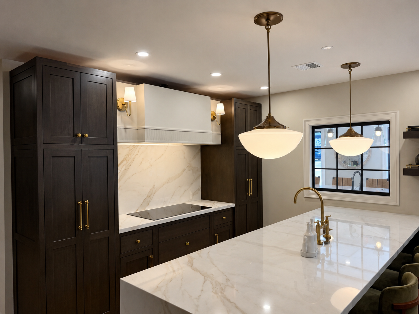 Wall sconces over dark cabinetry with marble backsplash in Hanover MA kitchen by Luster and Volt